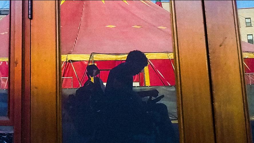 The shadow of documentarian Reid Davenport in front of a circus tent