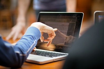 People sitting around a laptop